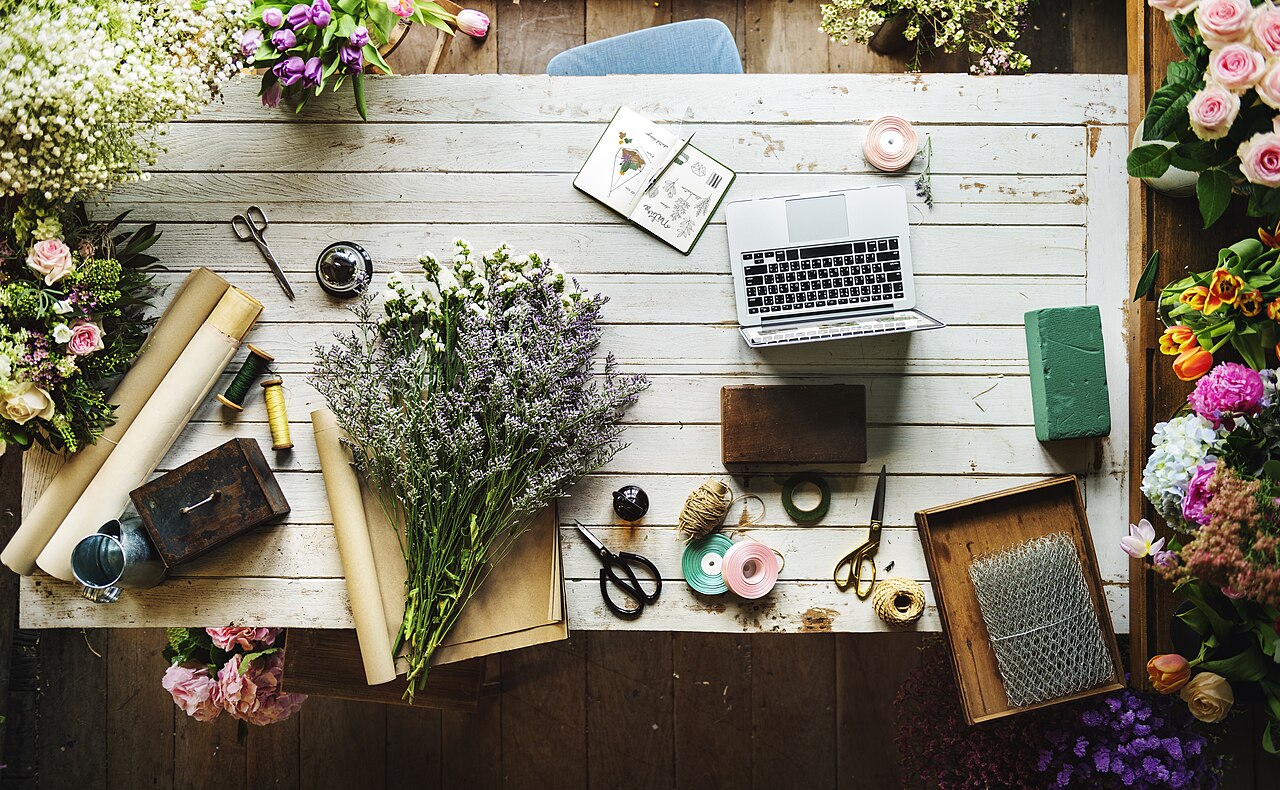 Table de travail d'un fleuriste avec fleurs et outils (photo d'illustration)